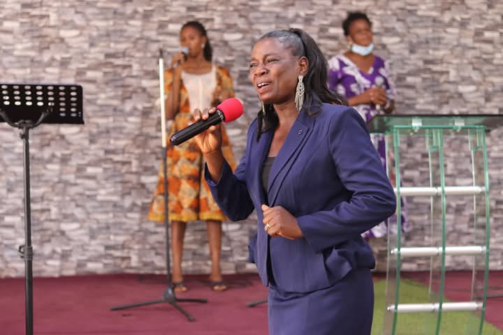 Rev. Helena Ramatu Abdulai ministering with a microphone in church